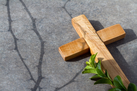 Wooden cross with sprig of boxwood and shadow of thorns, Passion of Christ, easter religious abstractの写真素材