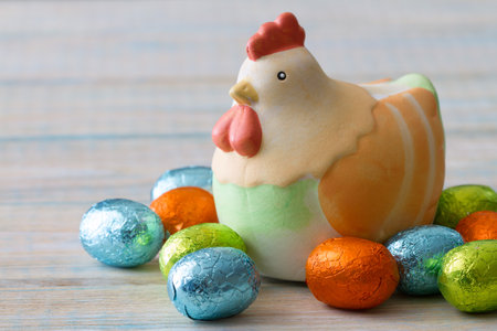 Chocolate easter egg with hen on light wooden background, easter sweets, decorationの写真素材