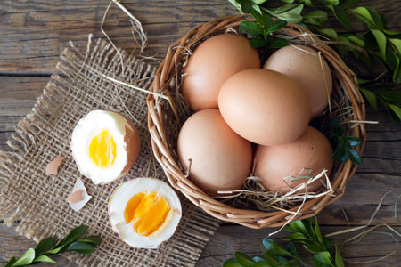 Eggs in basket decorated with boxwood on wooden boards, easter conceptの写真素材