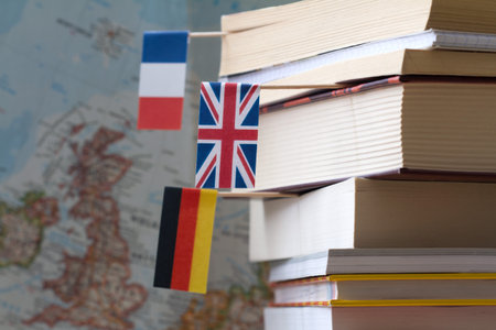 Stack of books with country flags on background of map, foreign language learning conceptの写真素材
