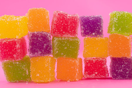 Closed up three spiral shape jelly candy, yellow red orange roll with sugar surface, pastel bright...