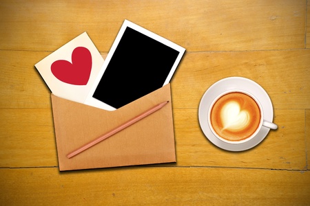 An open envelope with photo, pencil, red heart and cup of coffeeの写真素材