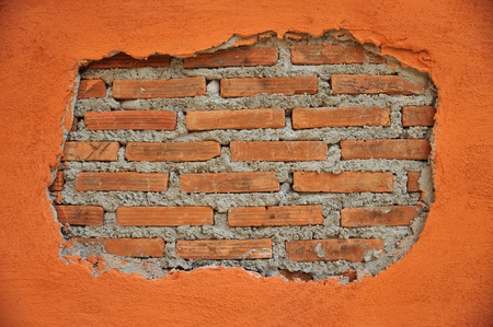 A  cracked wall reveal a brick wall insideの写真素材