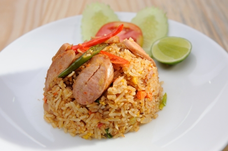 Sausage fried rice on white dish and wooden table の写真素材