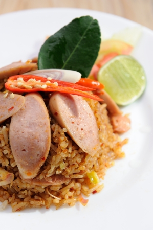 Sausage fried rice on white dish and wooden table の写真素材
