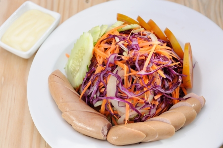 Sausage salad on white dish and wooden table の写真素材