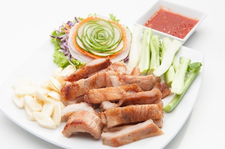 Fried pork served with various vegetables on white dish の写真素材
