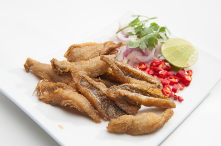 Fried fish served on white dish の写真素材