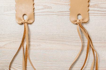 Faux leather strap with ties on a decorative background