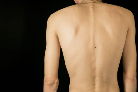 A fragment of the naked body of a young man on a dark backgroundの写真素材