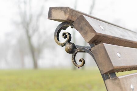Fragment of a decorative Park bench in rainy weatherの写真素材