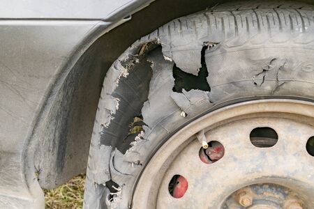 The punched and torn tire of a wheel of the carの写真素材