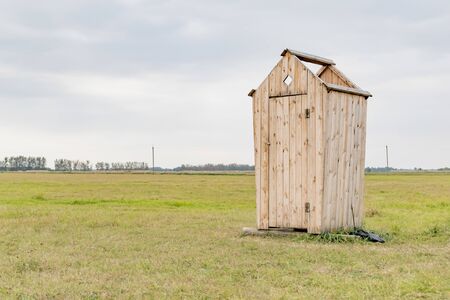 Wooden toilet cubicle standing in the fieldの写真素材