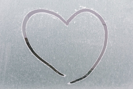A heart drawn on a frozen car window after a frost