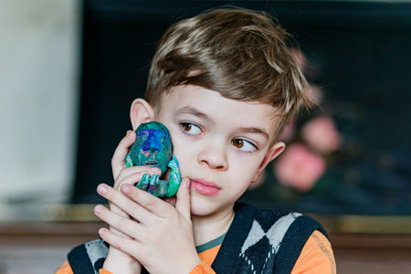 A little boy shows his craft made of plasticine