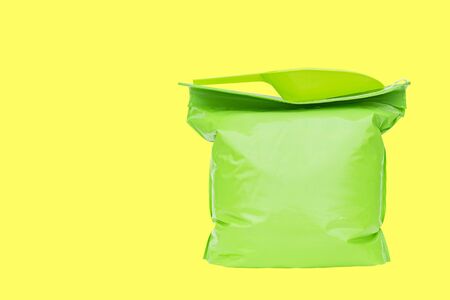 Sealed packaging bag for transporting goods and ladle for filling on a white backgroundの写真素材