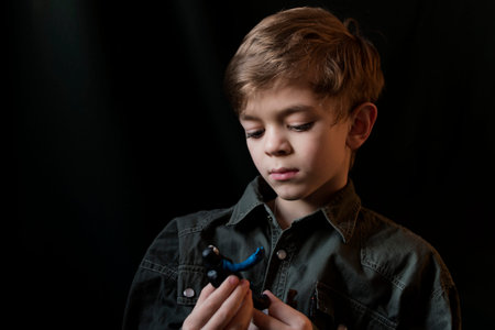 Portrait image of a small boy with brown eyes on a dark background