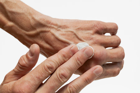A man rubs his hands with white cream after work
