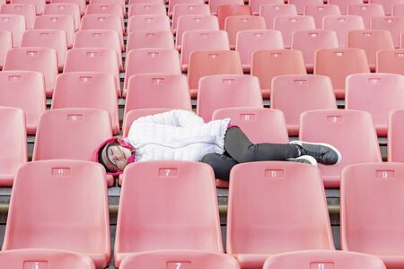 A young girl on the podium of an empty stadiumの写真素材