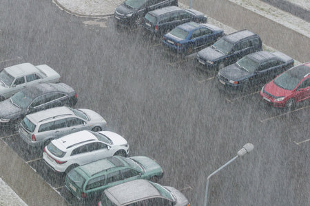 Top view of a Parking lot with cars during a snowfall