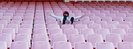 A young girl on the podium of an empty stadiumの写真素材