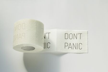 A roll of white toilet paper with an inscription on the backgroundの写真素材