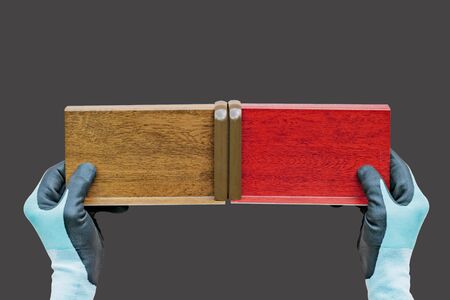 A gloved installer holds laminated metal castings for installation on plastic Windows in different colorsの写真素材