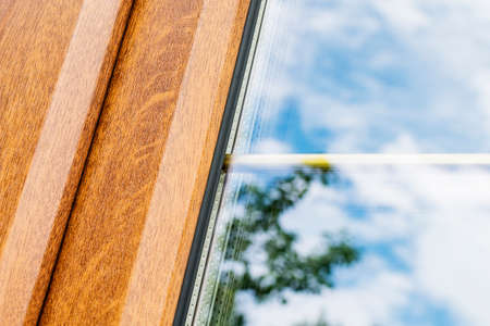 A fragment of a plastic laminated window with partitions in mirrored double-glazed Windowsの写真素材