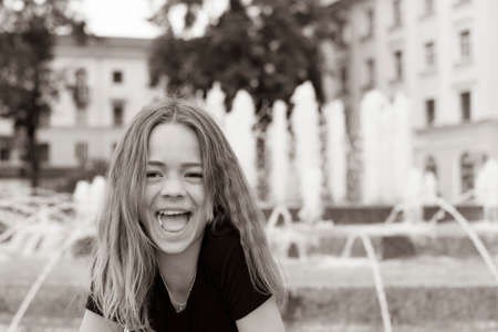 A young girl plays in the city's water fountainの写真素材