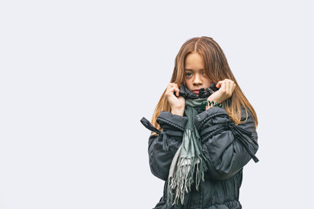 Young girl in warm clothes in autumn on a light backgroundの写真素材