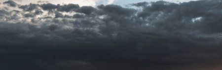 Harsh autumn sky at sunset. Dark heavy clouds