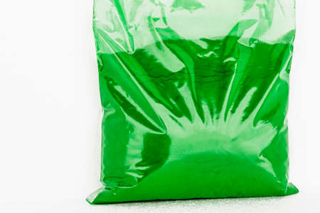 Transparent plastic packaging bag with small bulk goods of green colorの写真素材