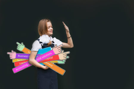Young girl student in uniform holding textbooks on a dark background