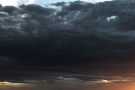 Harsh autumn sky at sunset. Dark heavy clouds