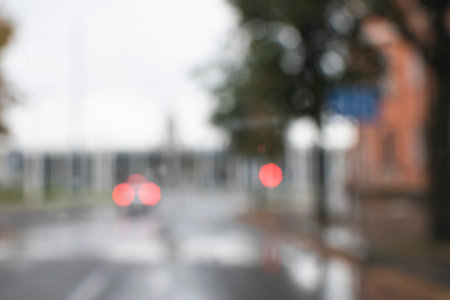 Blurry image through the car window. Autumn landscape of the city during the rain