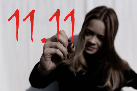 A young girl draws the numbers 11.11 with a pencil. This is the start date of discounts in the...