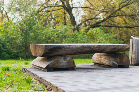 Wooden benches made of cut logs in the city Park. Decorative work