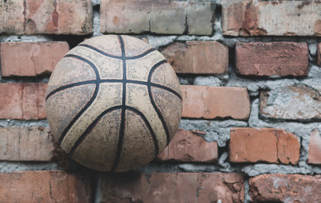 An old battered basketball against a brick wallの写真素材