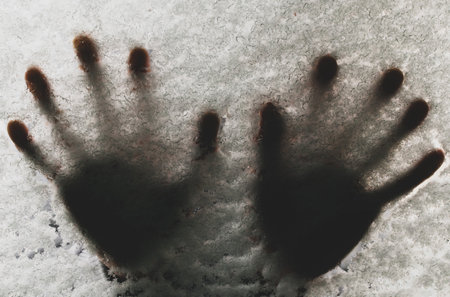 Handprints on a snow-covered car window in winter cold weatherの写真素材