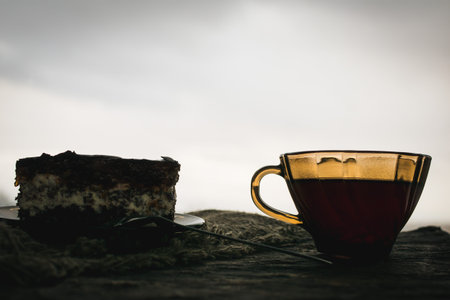 Tinted image of a cake and a cup of tea with lemon on a decorative backgroundの写真素材