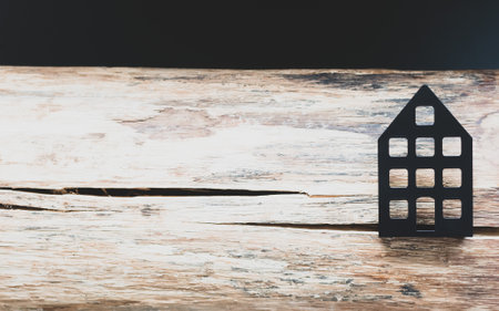 A dried piece of log with cracks and a metal layout of the house on a decorative backgroundの写真素材
