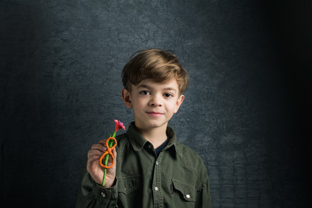 The little boy holds in hand crafts from clay, flower gift on March 8の写真素材