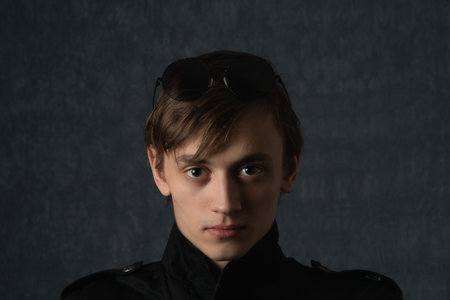 Portrait image of a young man in dark clothes indoorsの写真素材