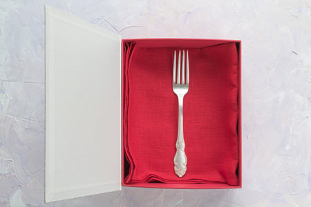Dining fork for food on a red linen napkin in a gift boxの写真素材