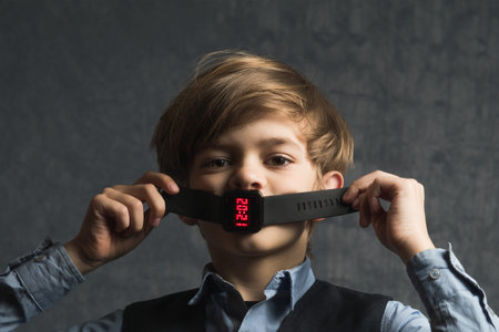 Portrait image of a small boy with a wrist electronic watch