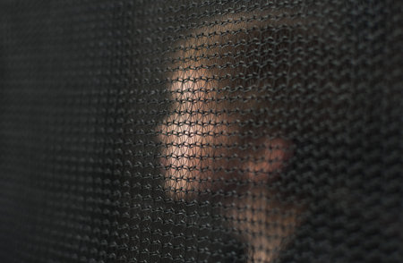 Blurry image of a little boy through a trampoline safety net