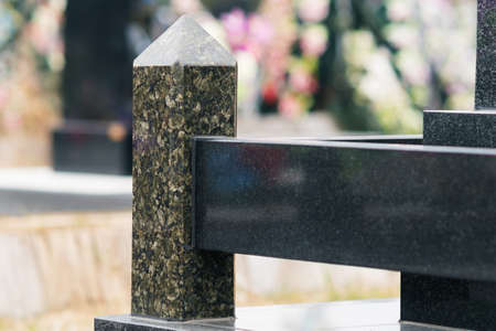 Fragment of a dark granite tombstone on the graveの写真素材