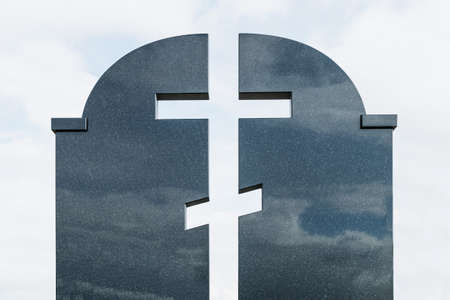 A fragment of a dark granite tombstone on the grave in the form of an Orthodox crossの写真素材