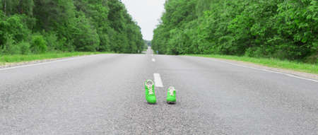 Sports boots with green spikes are on the roadの写真素材