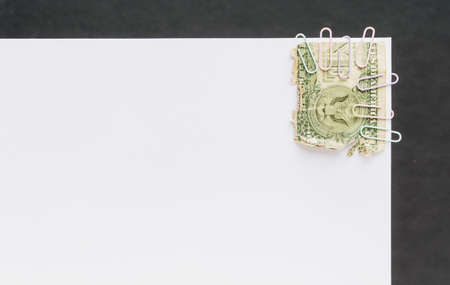 Half of a dollar bill attached to the white sheet of the albumの写真素材